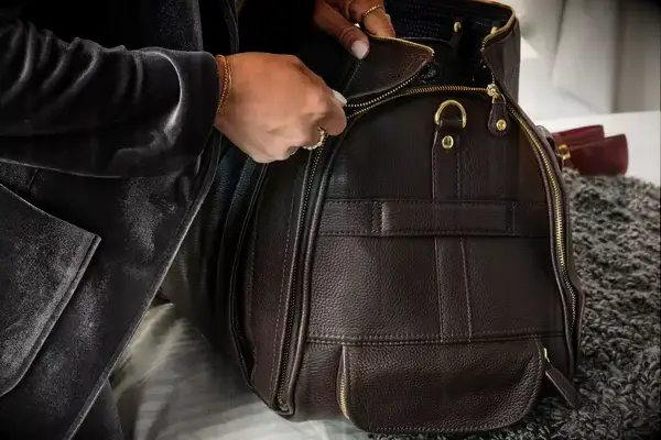 Hand zipping up the Eagle Creek 130L Cargo Hauler Rolling Duffel