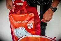 Hand zipping up the Eagle Creek 130L Cargo Hauler Rolling Duffel