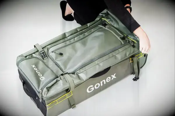 Person zipping Gonex Rolling Duffel Bag With Wheels