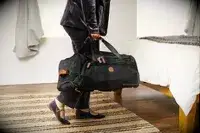 Person rolling Samsonite Just Right Weekend Wheeled Duffel around cones during testing