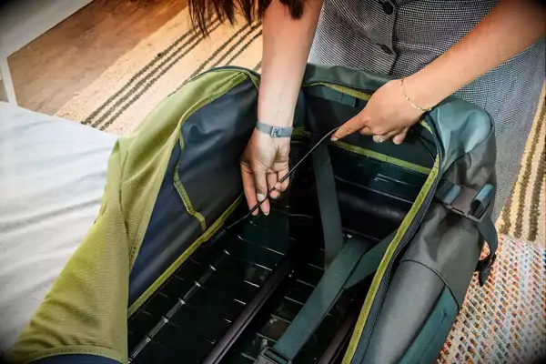 A person adjusts the Away The Outdoor Rolling Duffel 85L