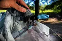 A person holds up the ties on the Sea to Summit Telos Freestanding Ultralight Tent