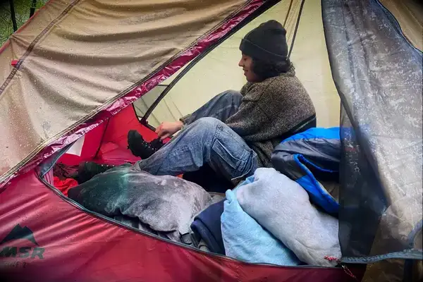 A person sits inside a MSR FreeLite 2-Person Ultralight Backpacking Tent