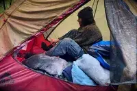 A person sits inside a MSR FreeLite 2-Person Ultralight Backpacking Tent