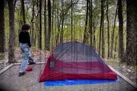 A person stands outside a MSR FreeLite 2-Person Ultralight Backpacking Tent