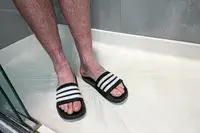 A person stands in the shower while wearing the Adidas Men