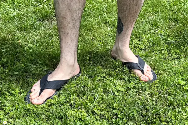 A person wears the Reef The Deckhand sandals in grass