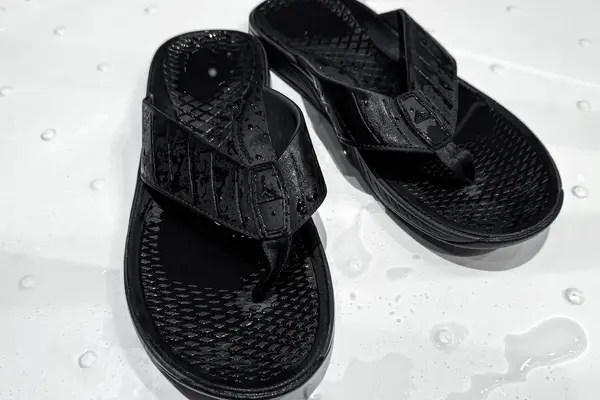 An overhead view of a pair of Reef The Deckhand sandals in a shower