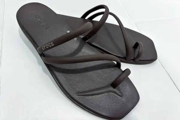 A pair of Crocs Miami Toe Loop Sandals on tile