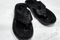 An overhead view of a pair of Reef The Deckhand sandals in a shower