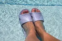 A person wears the Anmerl Travel Slippers in a pool