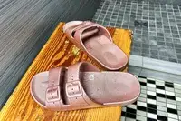 A pair of Freedom Moses Freedom Slides on a wooden bench