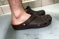 A side view of a person wearing the Crocs Classic Clogs