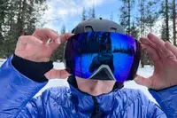 A person putting on the Smith I/O Mag Goggles