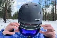 A person putting on the Smith I/O Mag Goggles 