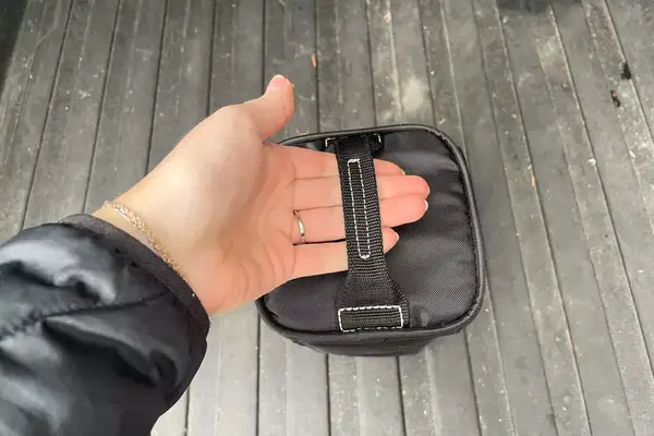 A person holding the carry bag for the Oakley Line Miner Pro L Snow Goggles