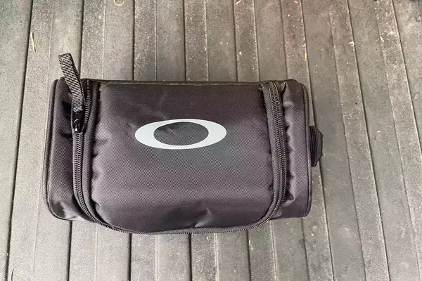 The carry bag for the Oakley Line Miner Pro L Snow Goggles on a wooden surface