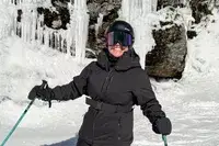 A person wearing the Dragon NFX Mag OTG goggles while skiing