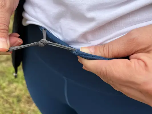 A person shows the string tie on the waist of the FjÃ¤llrÃ¤ven Women