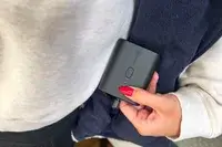 A person holds the battery pack for the Ororo Women’s Heated Recycled Fleece Vest