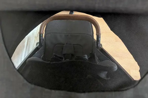 Nuna TRVL LX Stroller view from behind a mesh showing the handle and seating area