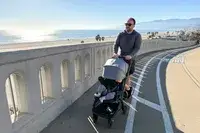 A person pushes the Uppababy Minu V3 Travel Stroller
