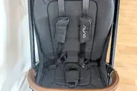 A closeup of Nuna TRVL LX Stroller seat with a harness and branding on the straps