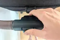Hand operating a latch on a Nuna TRVL LX Stroller