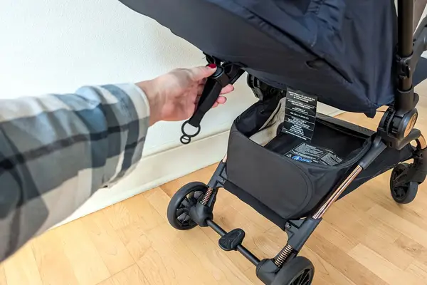 A person adjusts the strap on the Peg Perego Volo Compact Stroller