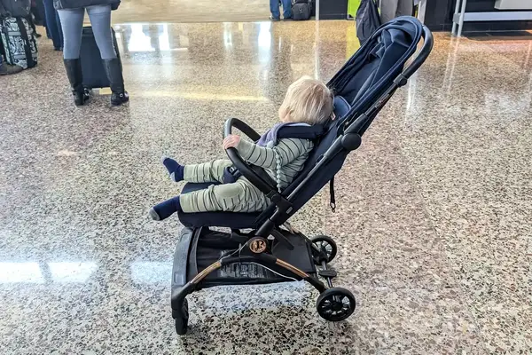 A baby sits in the Peg Perego Volo Compact Stroller