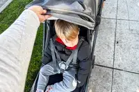 A child sits in the Uppababy Minu V3 Travel Stroller
