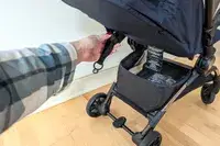 A person adjusts the strap on the Peg Perego Volo Compact Stroller