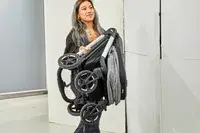 A person lifting a folded Thule Shine