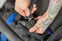 Two hands holding the buckle of the Thule Shine