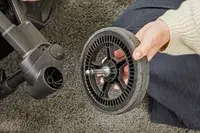 A hand assembling the wheel of the Thule Shine