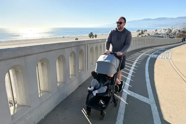 A person pushes the Uppababy Minu V3 Travel Stroller