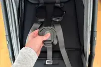 A person pushes the lock on the Uppababy Minu V3 Travel Stroller