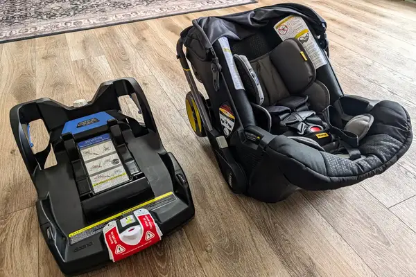 The Doona + Car Seat and base on a wooden floor