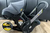 A side view of the Doona + Car Seat and stroller folded up