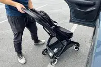 A person wheels the Bugaboo Butterfly Stroller over asphalt