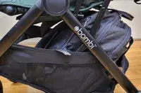 The logo on the side of the Bombi Bēbee V2 Lightweight Stroller