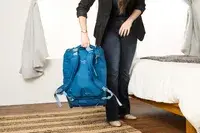 A person lifting the Osprey Daylite Wheeled Duffel 40L by the handle