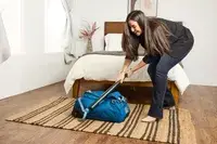 A person hitting the Osprey Daylite Wheeled Duffel 40L with a bat