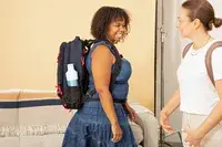 A person adjusts the straps on the Cotopaxi Allpa 42L Travel Pack
