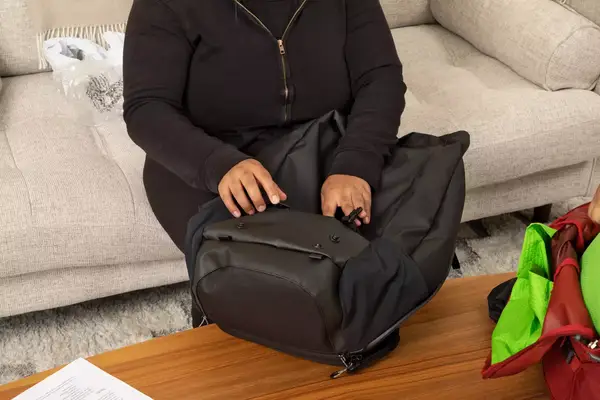 A person wears the Away The Outdoor Convertible Backpack 45L next to airplane seats