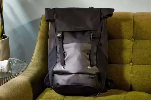 A person carries the Away The Outdoor Convertible Backpack 45L by the shoulder strap