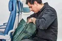 A person looks in the pocket of the Away The Outdoor Convertible Backpack 45L