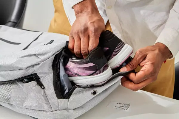 Person putting shoes inside Matein Travel Backpack 40L