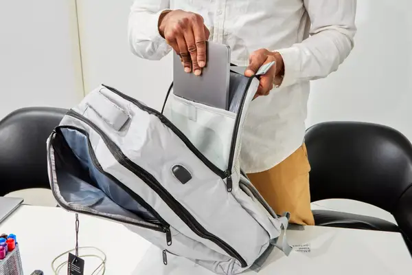 Person putting laptop inside pocket of Matein Travel Backpack 40L