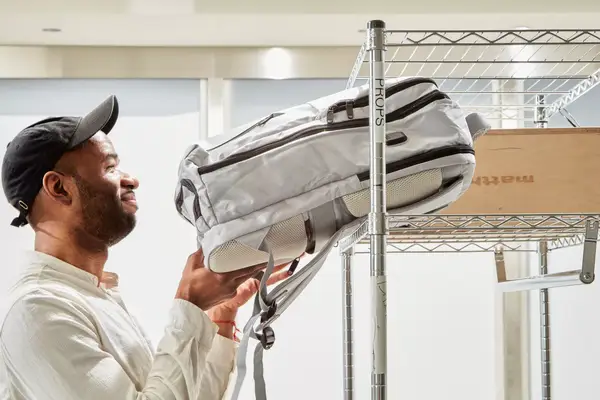 Person putting Matein Travel Backpack 40L on a shelf
